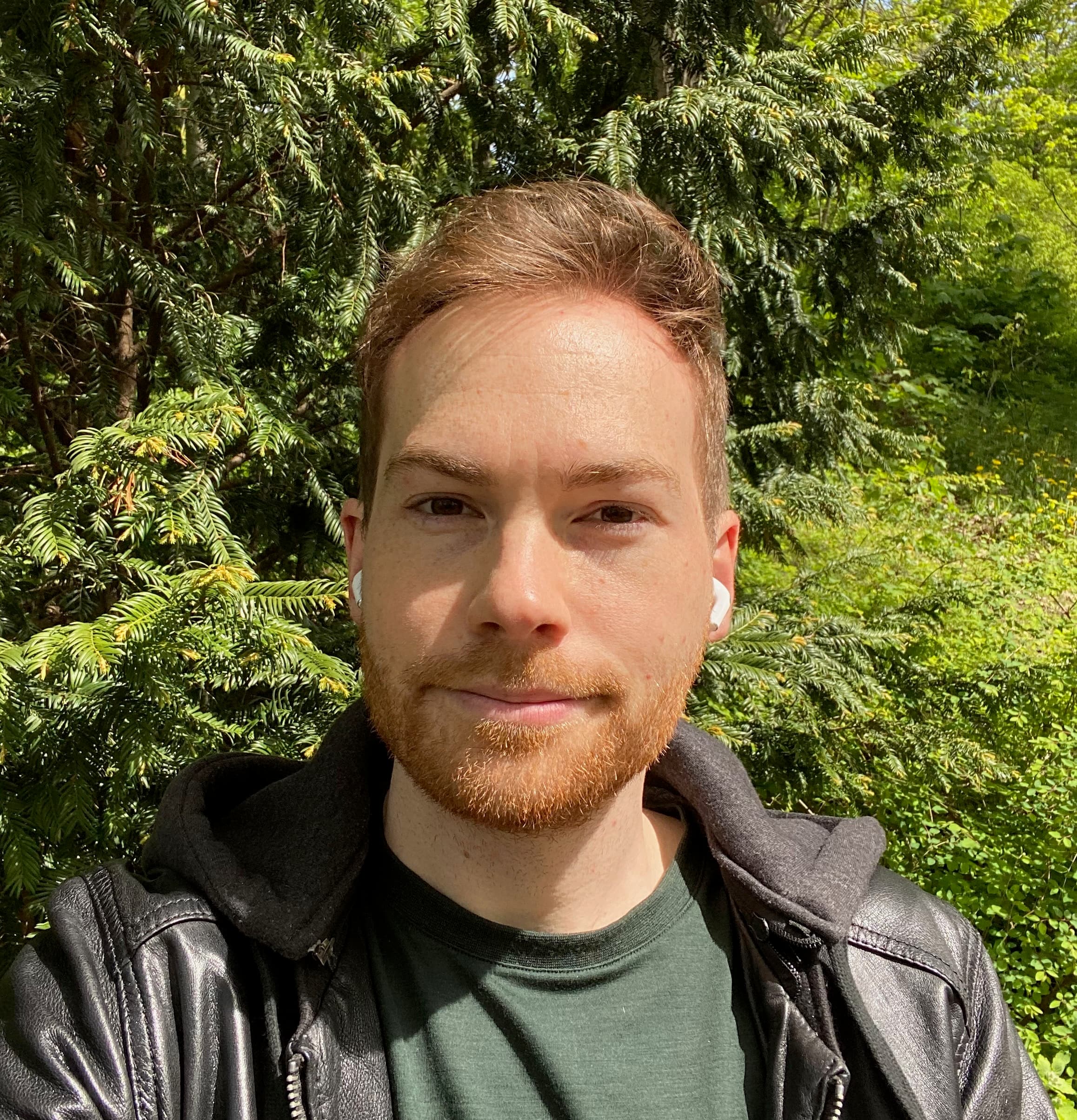 Daniel, co-founder of FoodQuest, in front of green trees